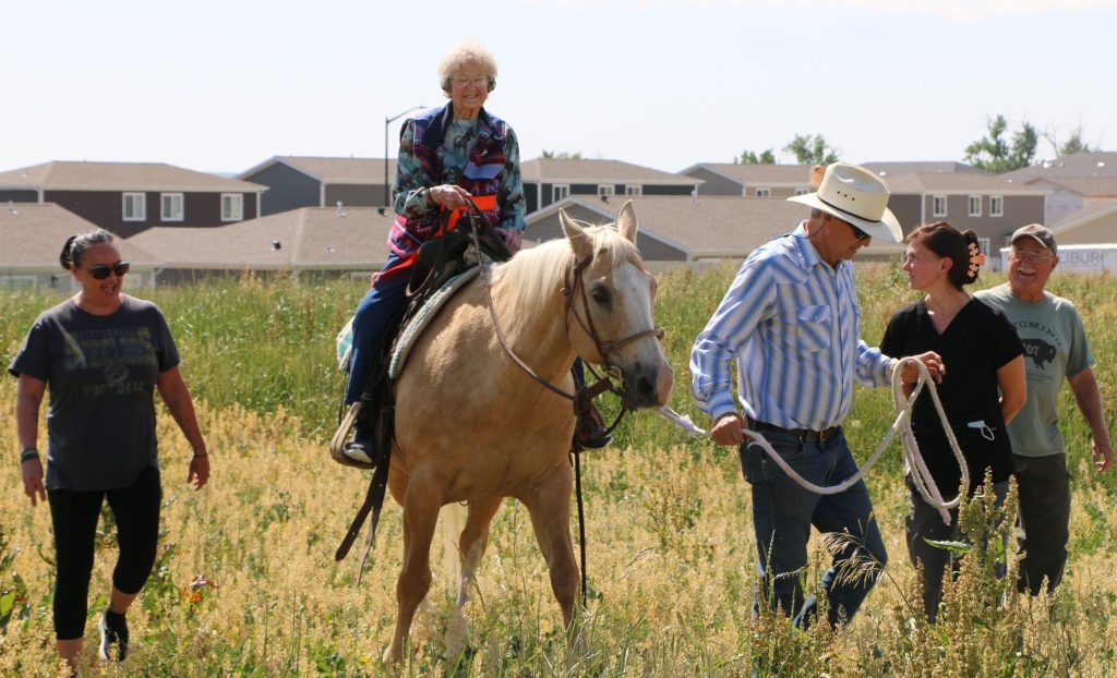 Dave, Trudy and Uno arrived at Sheridan Green House on a bright June morning. With a little help from licensed practical nurse Kayla Larsen and certified nursing assistant Jennifer Broadwater, Vera climbed into Uno’s saddle. Smiling proudly, Vera Montgomery rode Uno around the block while Dave led the way and a crowd of supporters walked beside her.